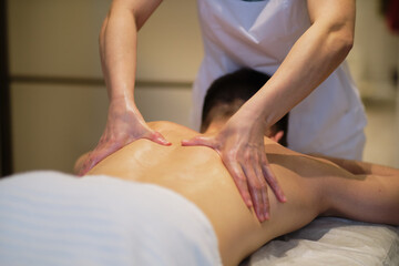 Close-up of man enjoying in relaxing shoulders massage . Man relaxing on massage table receiving massage
