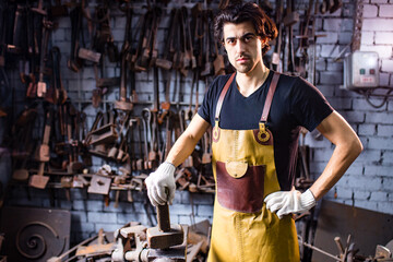 italian brunette man blacksmith working in the workshop