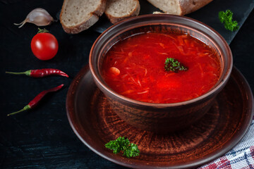 Borsch - beetroot soup in a clay bowl on a stone background,traditional dish of ukrainian cuisine.