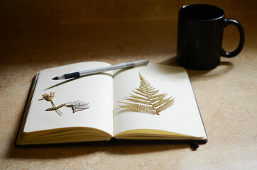 Minimalist desk mockup. Concept of writers journal. Nature meets work desk. Artistic and minimal journaling with dried ferns and natural lighting. 