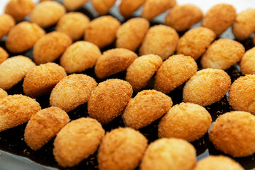 Rows of sweet golden cookies on a tray. Delicious pastries. Close-up.