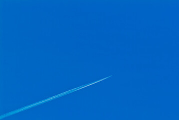 a white trail in the sky from a flying plane