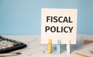 FISCAL POLICY on a sticker beside a calculator and a pen. Finances and business concept.