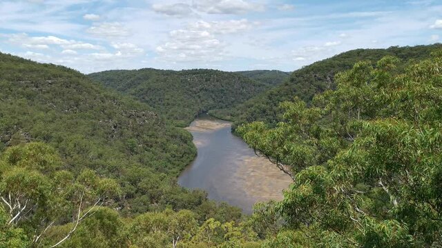 Beautiful video of a mountain top lookout of a creek with mountains and valleys on all sides and deep blue sky with puffy clouds, Naa Badu Lookout, Berowra Heights, Berowra Valley National park, Sydne
