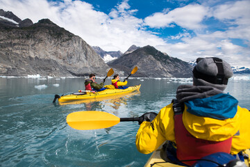 Group of friends enjoy ocean kayaking bear glacier during their vacation trip to in Alaska, USA - obrazy, fototapety, plakaty