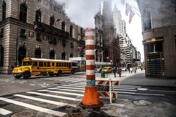 Steam heat pipe on New York city street construction work make fog and smoke - 415014898