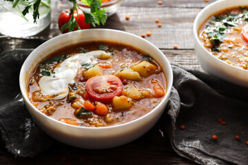 Red lentil soup and ingredients. Wooden background. Traditional spicy soup made from lentils and vegetables. Healthy vegan food