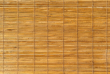 Background shot of a texture of a bamboo sun shade rolled down. Wooden blinds