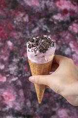 Blueberry icecream with chocolate chips in the waffle cone