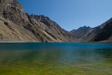 The colorful lake called Inca Lagoon in the Andes mountain range. The blue glacier water and yellow...
