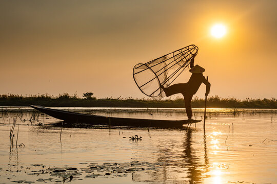 Fisherman at Inle Lake with traditional Intha conical net at sunset, fishing net, leg rowing style, Intha people, Inle Lake, Shan state