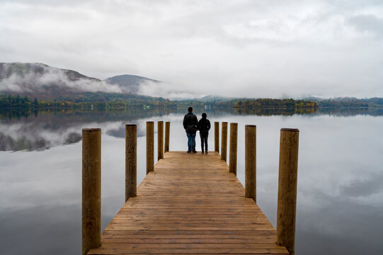 A couple standing on Ashness Pier Landing Jetty, Derwentwater, Keswick, Lake District National Park, Cumbria