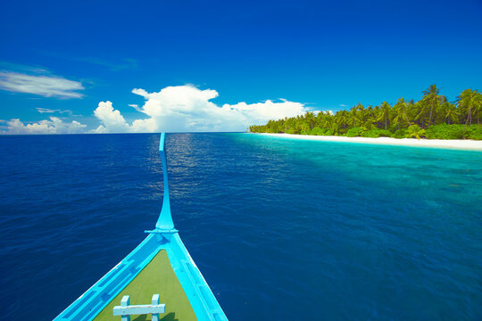 Maldivian fishing boat (dhoni) and tropical island, Maldives, Indian Ocean