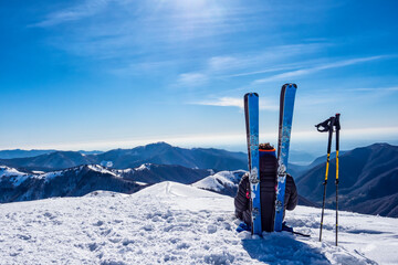 Ski mountaineer relaxing on the top of a mountain