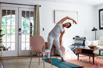 Black woman stretches at home before exercising