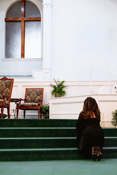 Black woman praying at church to God