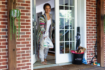Black woman grabs food delivered to front door at home
