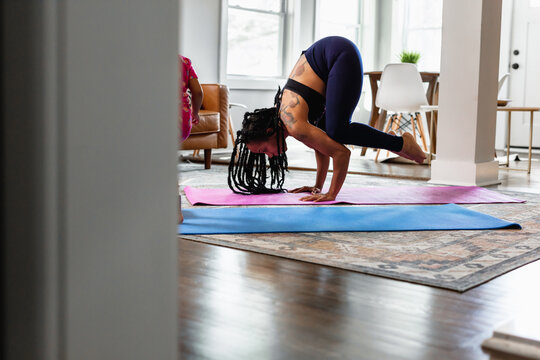 Woman with tattoo does yoga, crane crow