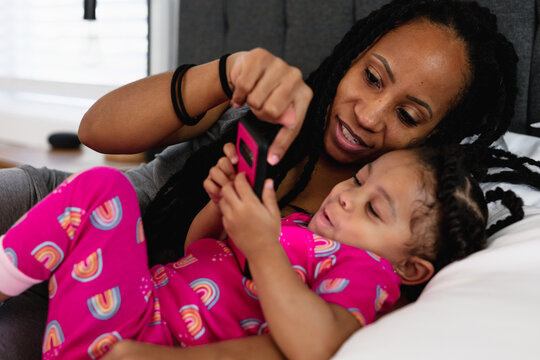 Black Mom And Daughter In Bed Watching Show On Phone