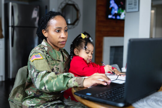 Focused military woman working from home at laptop