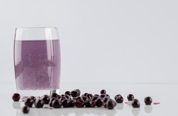 Blackcurrant confiture with a glass of juice on a white background