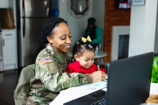 Military mom and daughter at home working