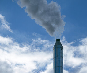 Smoke from chemical factory chimney on cloudy sky background. Ecology theme.