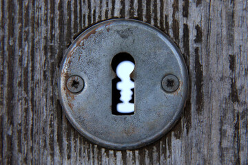 Keyhole and old door lock detail with wood background. 