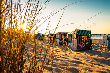 Sonnenuntergang zwischen einer Reihe von Strandkörben in Zinnowitz auf Usedom - obrazy, fototapety, plakaty