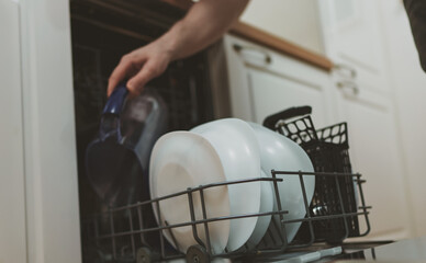 Man takes plastic jug from the dishwasher.