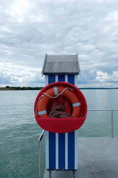 Germany, Schleswig Holstein, Stein, Jetty with blue and white beach cabin and lifebuoy on Baltic Sea