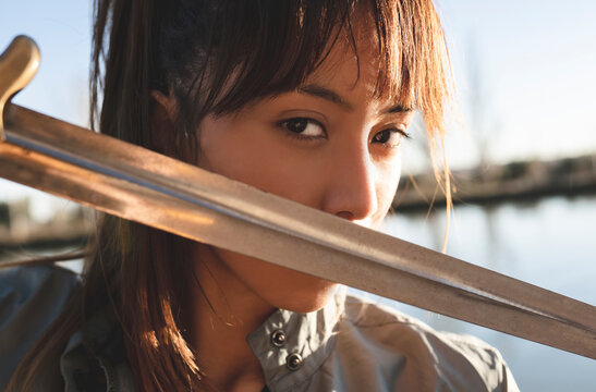 Female athlete staring with intense look practicing sword