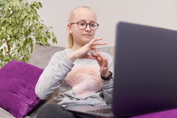 Deaf teenage girl talking gestures on laptop