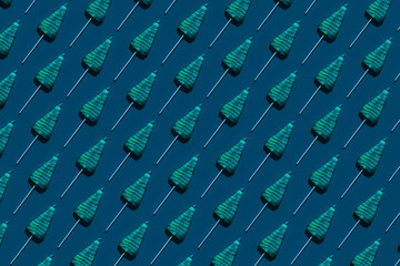 Pattern of tree-shaped lollipops against dark blue background