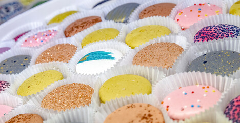 pasta of different colors on the counter in a pastry shop or store. Color background.