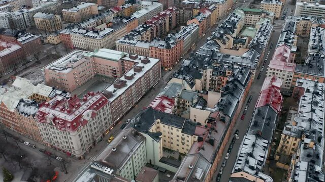 Aerial drone fottage of urban city with rooftops covered in snow