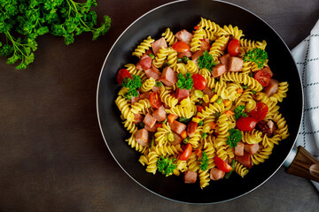 Rotini pasta with green peas, ham and parsley. Italian cuisine.