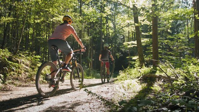 Two girls on mtb bikes. Mother and daughter riding on a forest trail.