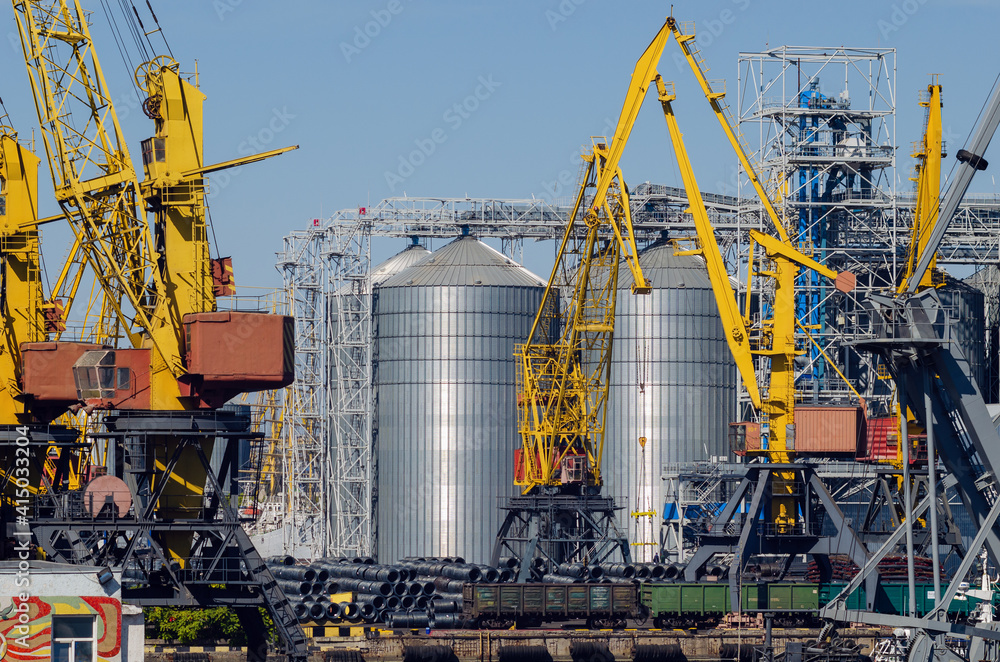 Wall mural lifting harbor cranes, shipping containers and granaries in the cargo seaport