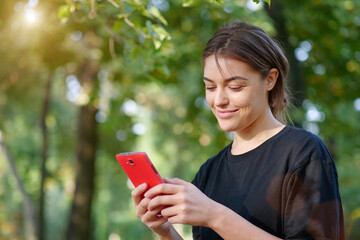 Beautiful young girl looks in smartphone