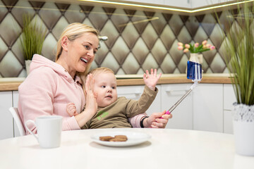 mom and son chat on the phone and wave their hands. high quality