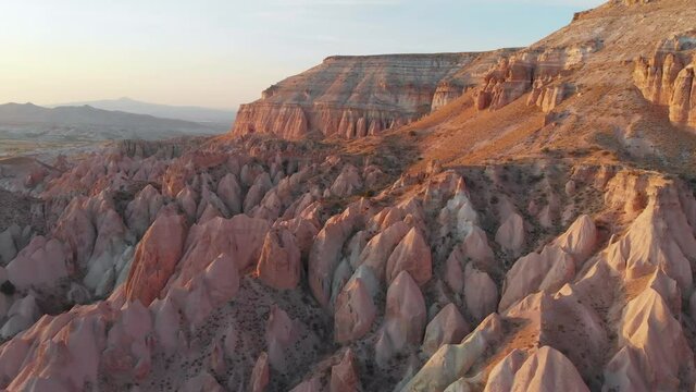 Cappadocia aerial drone view to sunset in Red and Rose valley rock formation, ancient cave churches. Goreme, Cappadocia, Turkey
