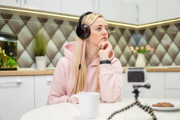 Girl blogger with blonde hair doing video on action camera