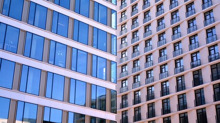 Facade texture of a glass mirrored office building. A beautiful background of an glass office building, reflecting clouds in the windows.