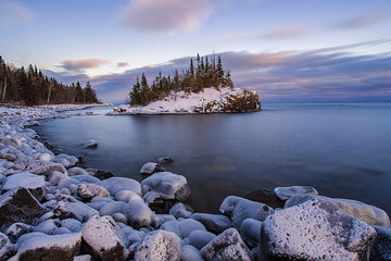 A snow covered island on the Minnesota shoreline on Lake Superior. - obrazy, fototapety, plakaty
