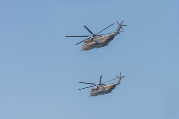 Fototapeta na wymiar Two military helicopters in the blue sky in Tel Aviv. Independence Day in Israel. Israel Air Force parade