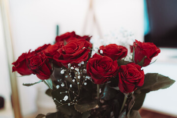 Red roses with white flowers in a vase - home decoration