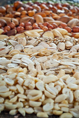 Many kinds of nuts close up. Heap of nuts on a black wooden board. Nuts are stacked on the table.
