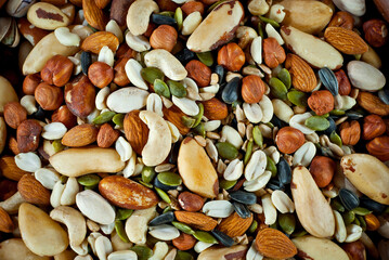 Many types of nuts close up. Textures of different nuts. Nuts are dumped in a pile. Contrasting...