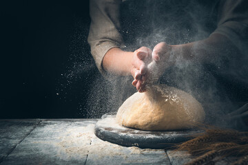 The preparation of bread. Knead the dough in a cloud of dust from the flour. The concept of making...